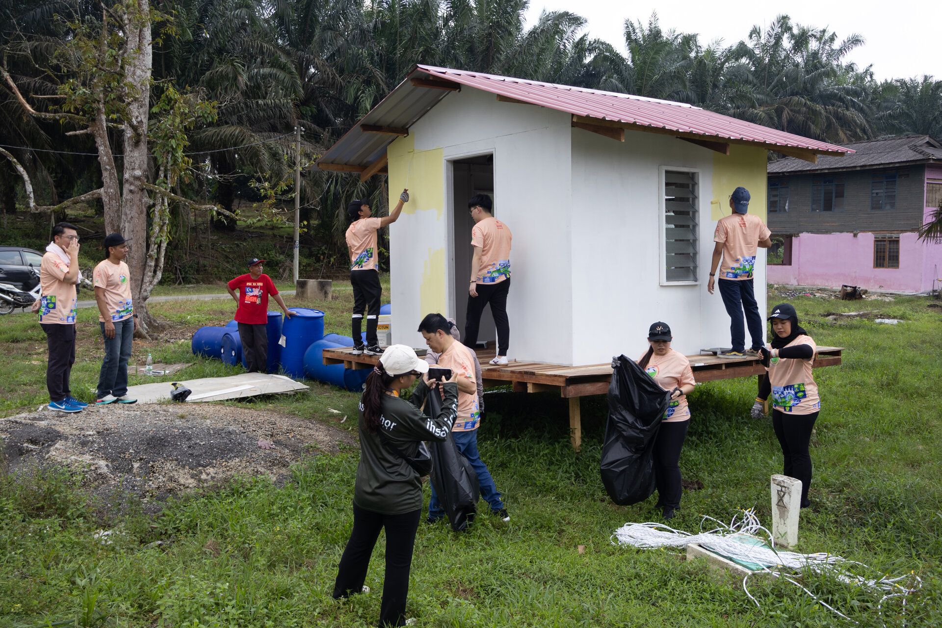 Staff volunteers painting and beautifying a Floating House in Kota Tinggi, Johor as part of community restoration efforts.