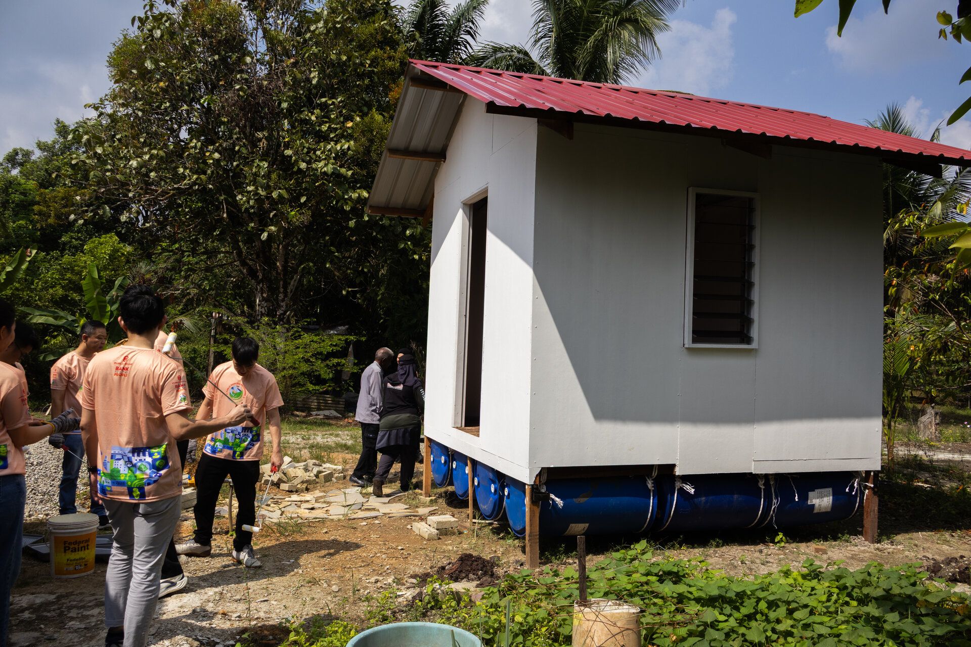 Staff volunteers assisting in the construction and completion of a Floating House as part of efforts to support flood-affected communities in Johor.
