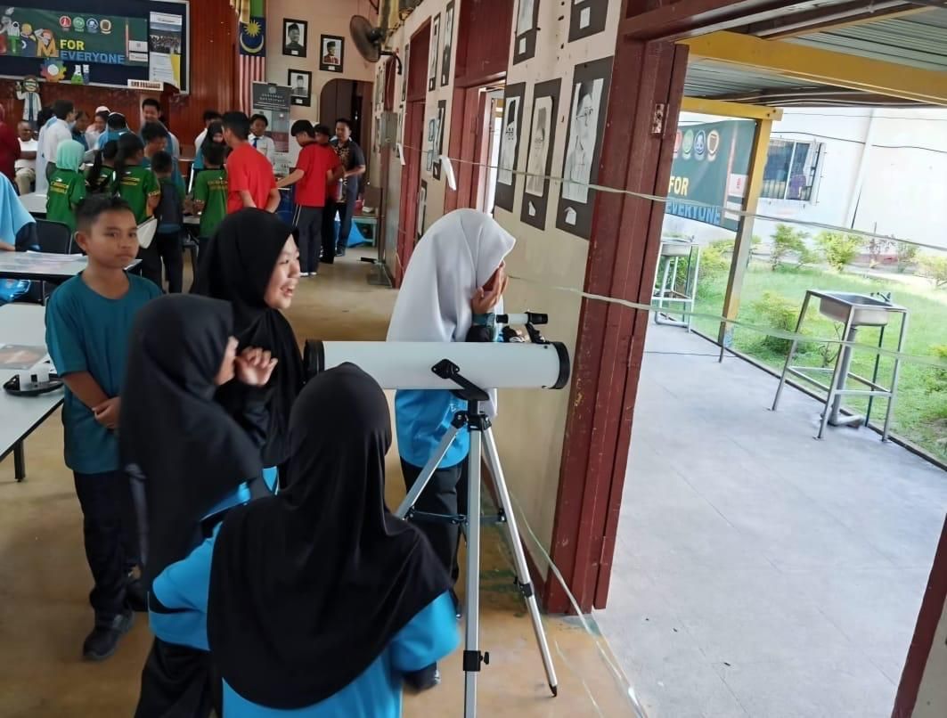 Students engaging in a hands-on astronomical observation using an optical telescope.